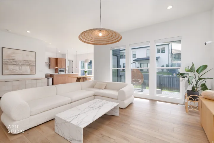 Open-concept living space featuring wood-finish flooring, recessed lighting, and a woven pendant light fixture