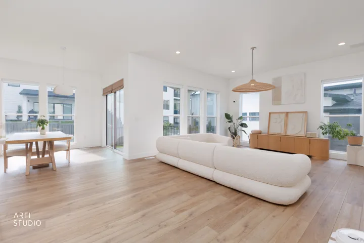 Open-concept living space featuring wood-finish flooring, recessed lighting, and large windows