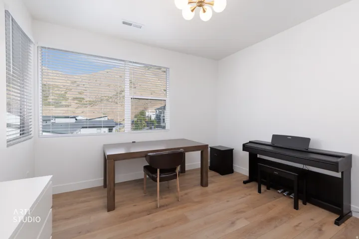 Expansive windows, wood-finish flooring, and a contemporary ceiling light fixture
