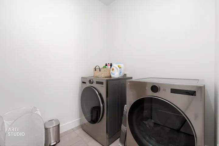 Front-loading washer and dryer set, neutral wall color, and light-toned flooring