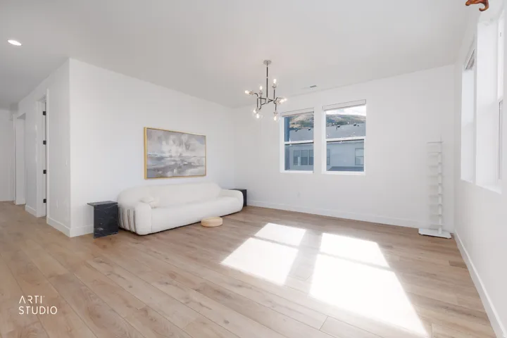 Recessed lighting, wood-finish flooring, abundant natural light, contemporary chandelier, and white wall finishes