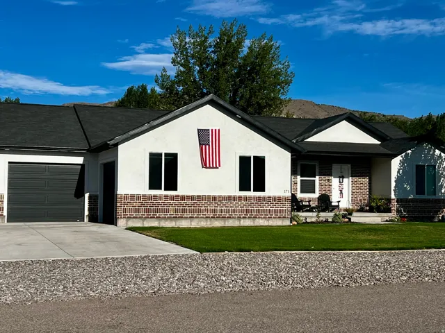 Contemporary ranch-style residence featuring a combination of white stucco and brick facade