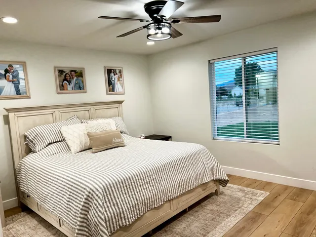 Spacious room featuring wood-finish flooring, a ceiling fan with integrated lighting, and recessed ceiling lights
