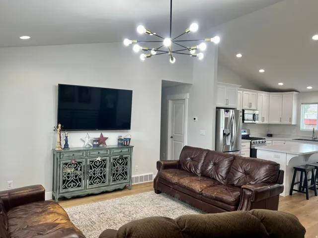 Vaulted ceilings with recessed lighting and a modern sputnik chandelier