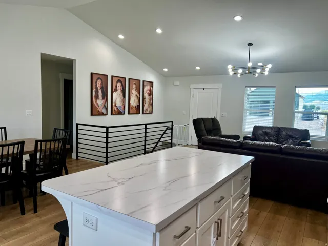 Central kitchen island with a stone-finish countertop and white cabinetry