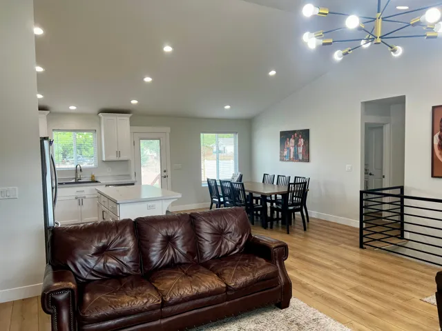 Open-concept living space with vaulted ceilings, recessed lighting, and wood-finish flooring