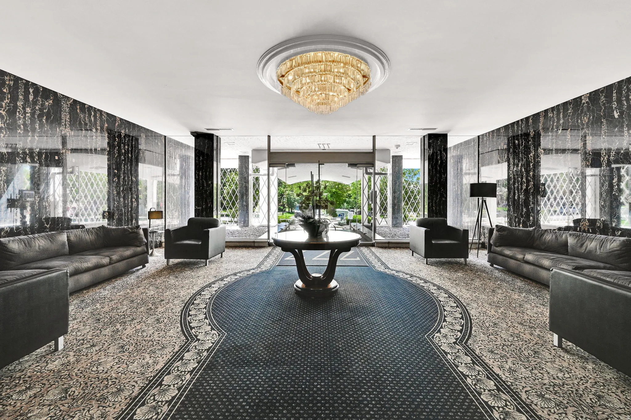 Ornate chandelier lighting, patterned wall finishes, decorative ceiling medallion, and large windows with decorative grilles