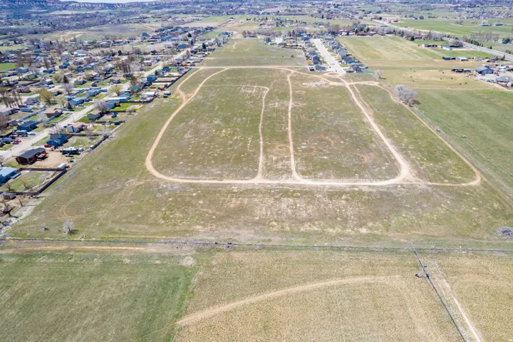 Expansive land parcel with established dirt tracks, surrounded by residential areas and open fields