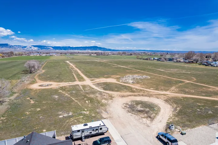 Expansive agricultural land featuring a natural terrain and distant mountain ranges