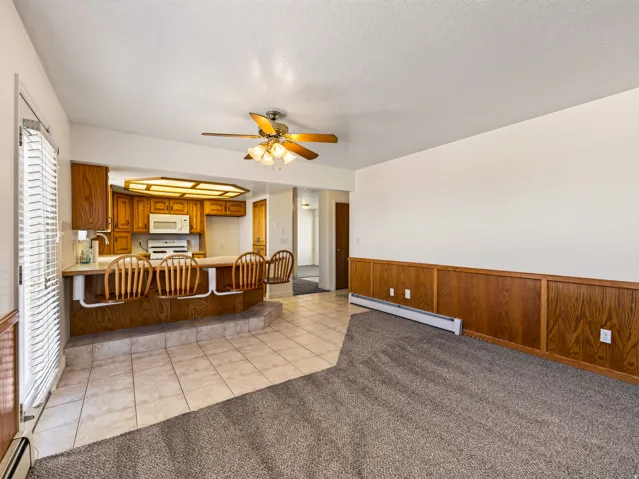 Kitchen with wood cabinetry, integrated appliances, and a breakfast bar