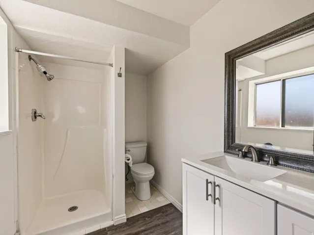 White shaker-style vanity with a single basin sink and brushed nickel hardware