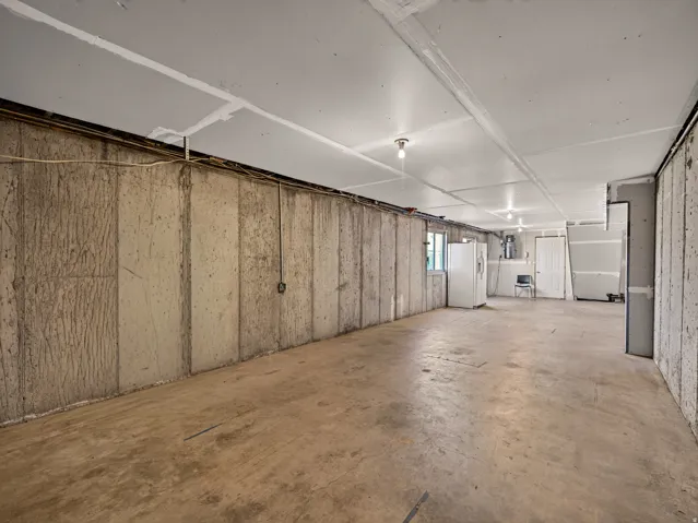 Unfinished basement space with concrete walls and flooring