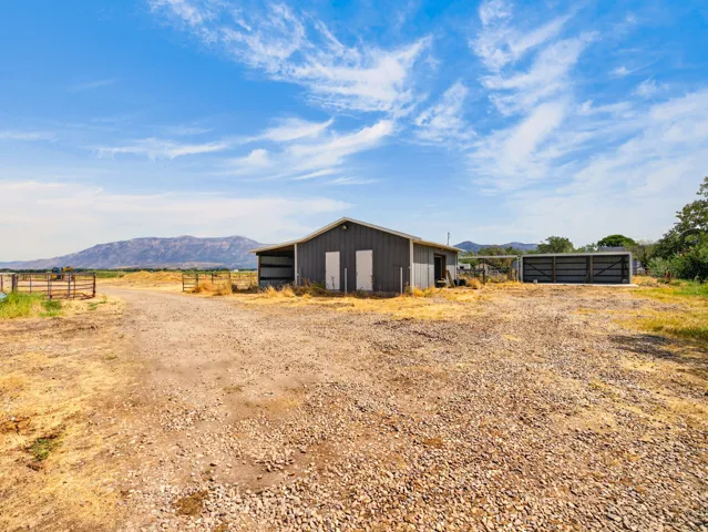 Metal-sided barn structure with an attached open-sided shelter