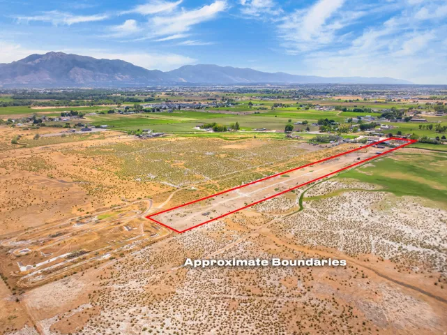 Expansive undeveloped land featuring natural terrain and distant mountainous backdrop