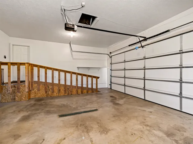 Garage space featuring an overhead door, concrete flooring, and an automatic garage door opener