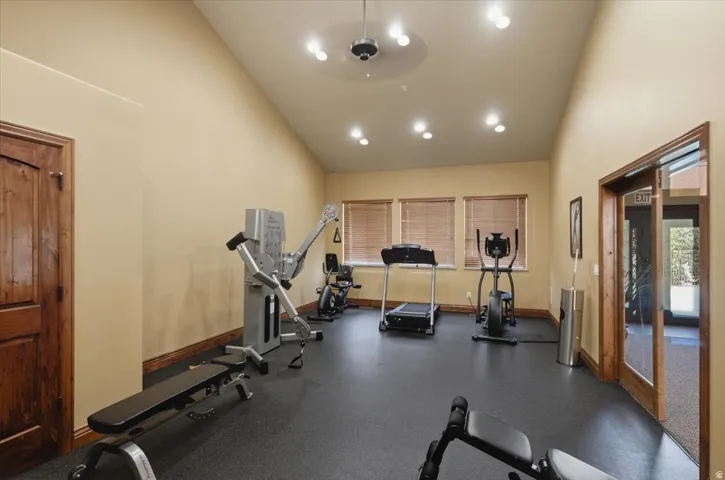 HOA Exercise Room Room featuring vaulted ceilings, recessed lighting, rubber flooring, and wood-paneled doors