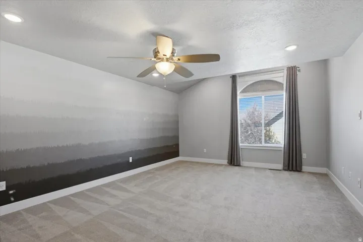 Vaulted ceiling with a ceiling fan and recessed lighting