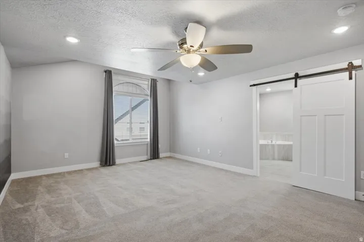 Spacious room with recessed lighting, a ceiling fan, and carpet flooring