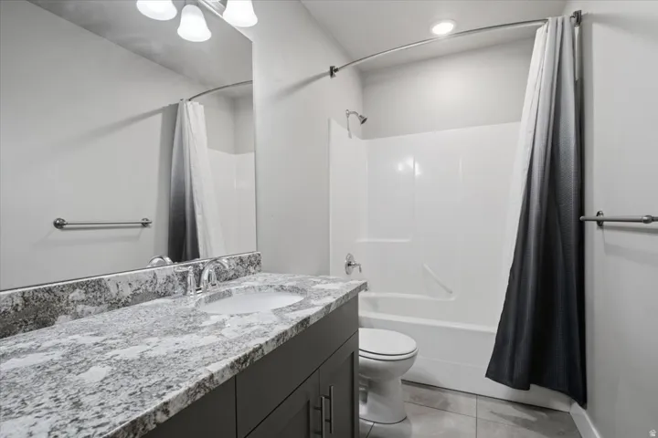 Vanity with stone-finish countertop, undermount sink, and chrome faucet