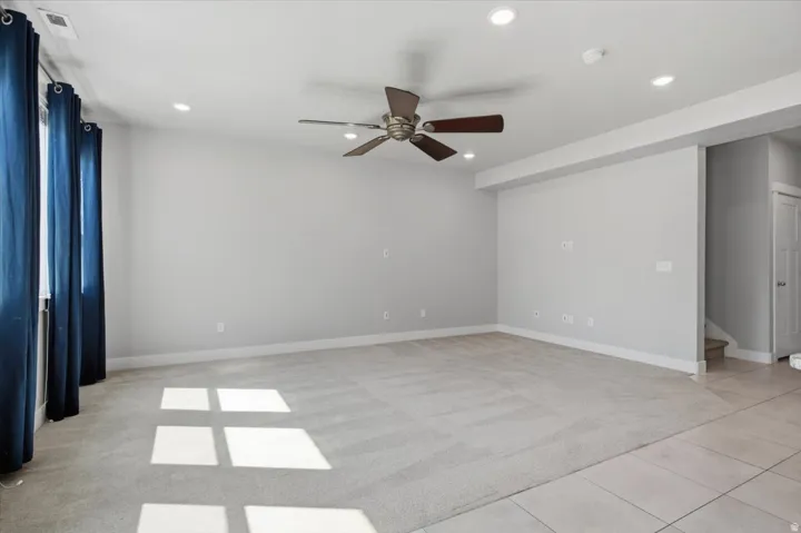 Recessed lighting, ceiling fan, neutral carpet, light-toned wall paint, and tiled flooring
