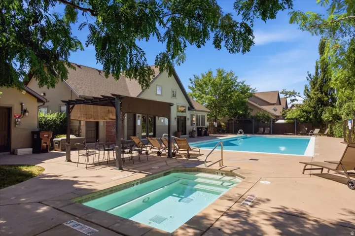 Outdoor amenity area featuring a swimming pool, separate spa, and paved sundeck