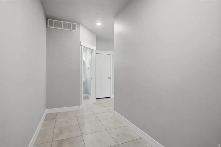 Neutral wall paint, recessed ceiling lighting, tile flooring, and white trim