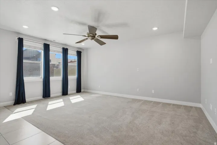Recessed ceiling lighting, ceiling fan, carpeted flooring, large windows, and neutral wall paint