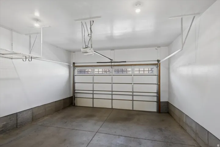 Concrete flooring, integrated garage door opener, and a panel garage door with upper window inserts
