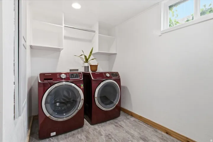 Convenient laundry area featuring tile flooring, built-in storage shelving, and a window for lots of natural light.