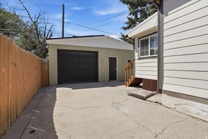 Detached garage with large, heated workshop featuring a dark garage door and a separate entry door for convenient access.