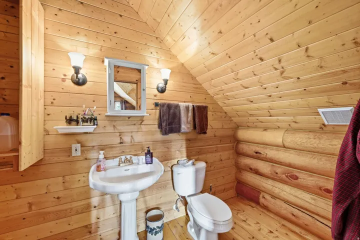 Wood-paneled walls and ceiling with a log accent wall