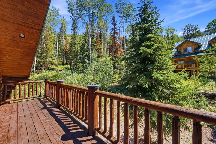 Wood-plank deck with a log railing system and exterior wood paneling