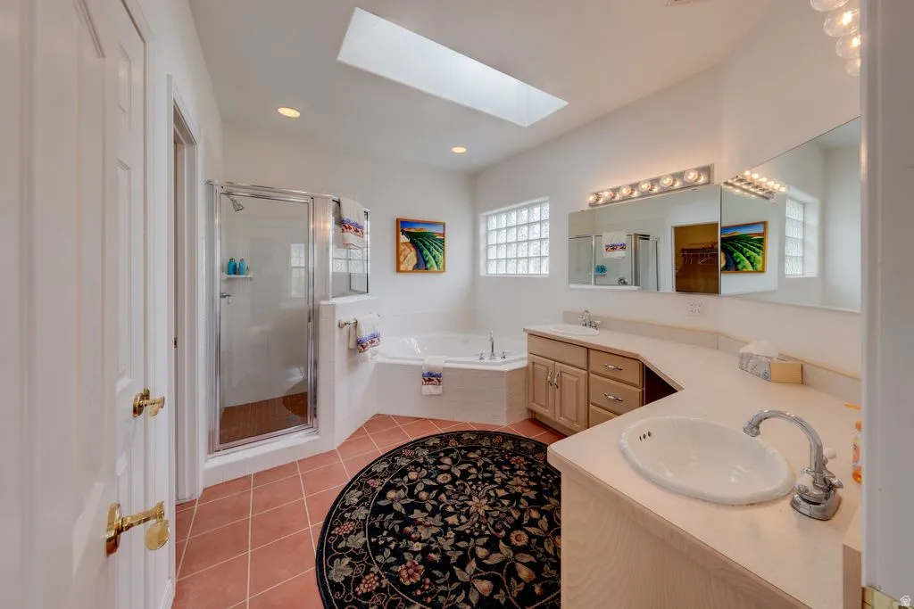 Spa-inspired master bathroom featuring dual vanities with wood cabinetry, quartz countertops, and polished chrome fixtures