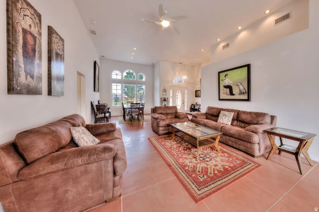 Vaulted ceilings, recessed lighting, ceiling fan, arched windows, and tile flooring