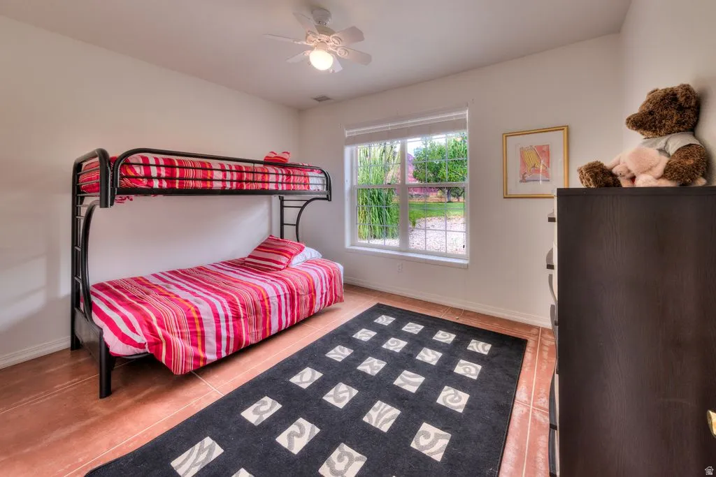 Recessed window with white blinds, ceiling fan with integrated lighting, and wood-finish flooring