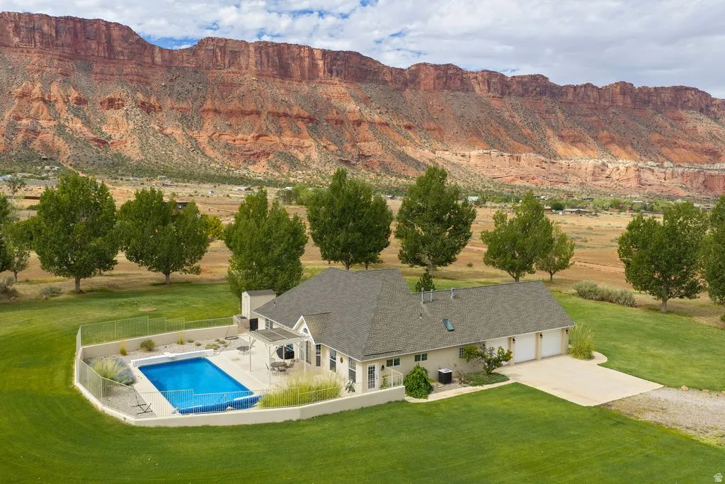 Expansive grounds with a well-maintained lawn, a private outdoor swimming pool, and a two-car garage