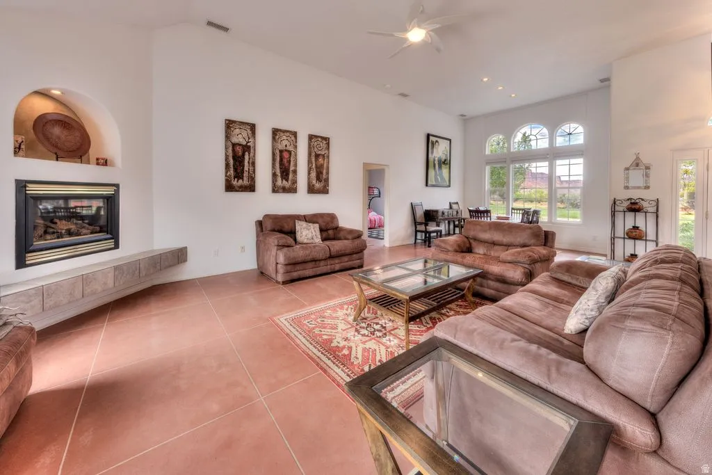Vaulted ceilings, a built-in fireplace with an arched niche, and tiled flooring