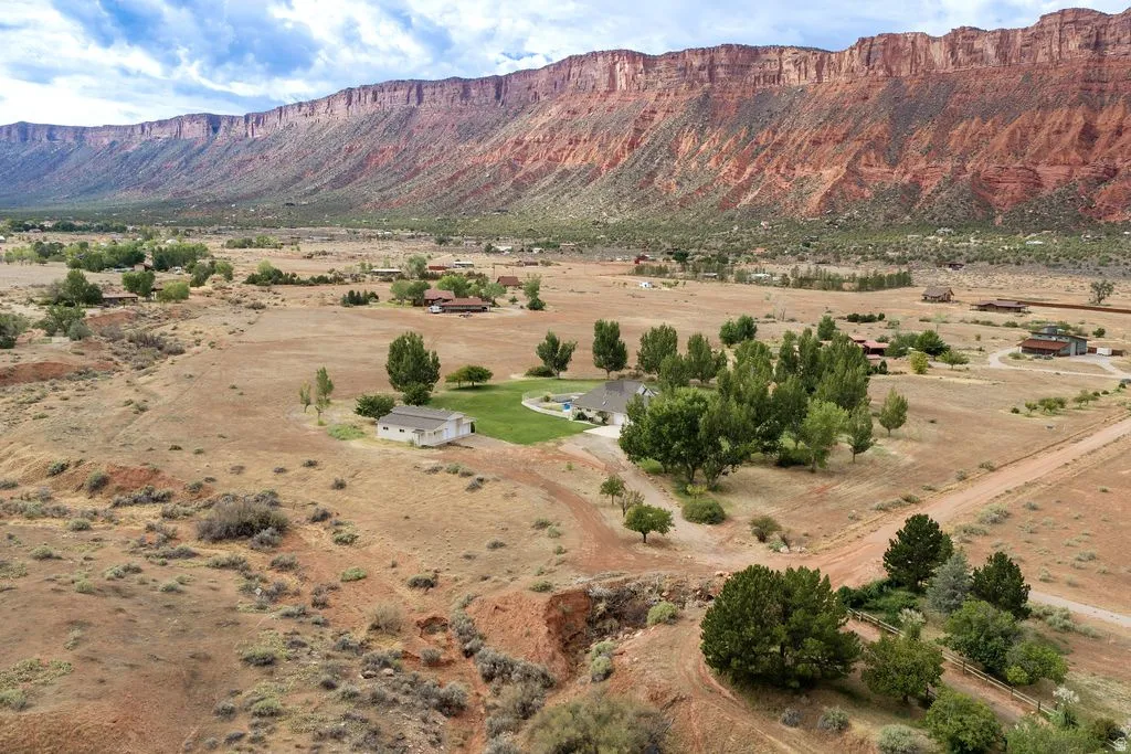 Expansive desert landscape featuring a prominent red rock mountain backdrop