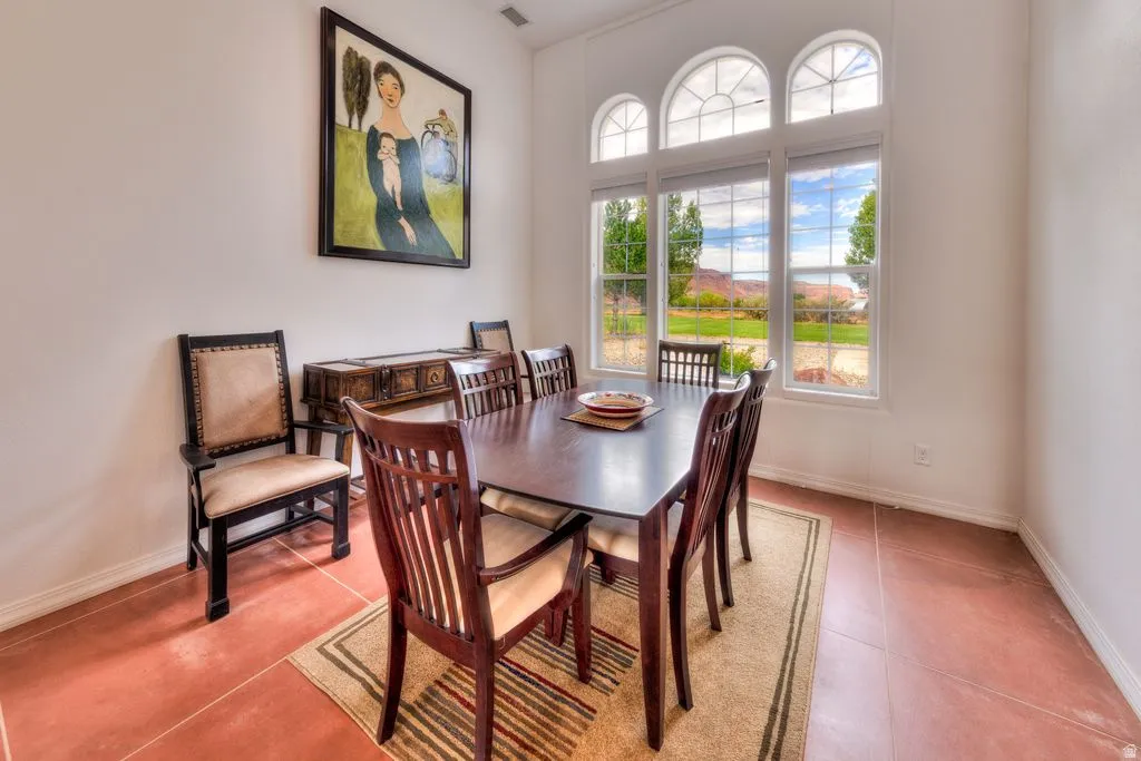 High ceilings, arched transom windows, three large windows, terracotta-style flooring, and a built-in credenza