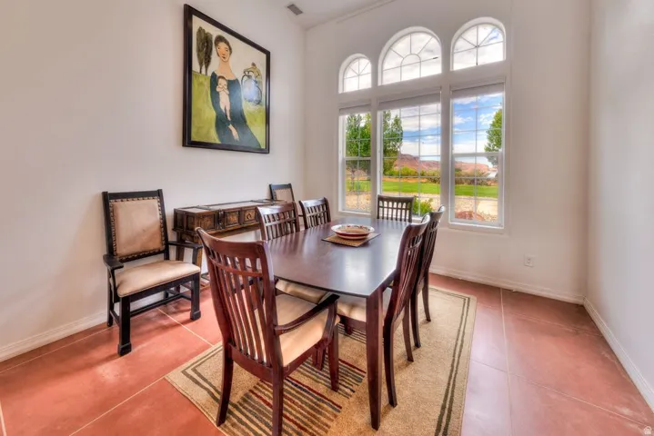 High ceilings, arched transom windows, three large windows, terracotta-style flooring, and a built-in credenza