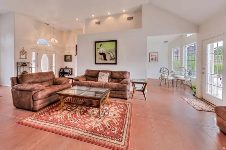 Vaulted ceilings, recessed lighting, and tile flooring