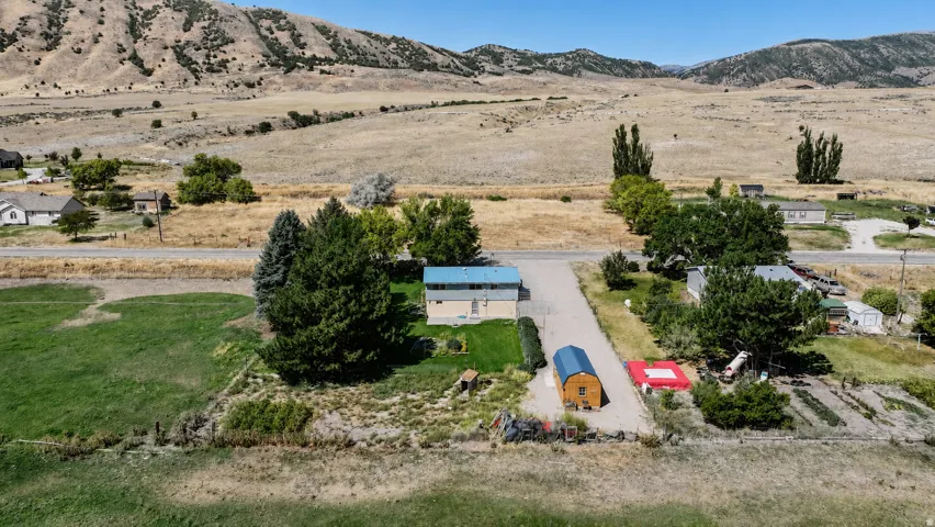 Expansive property with a single-story residence, detached outbuilding, and a large cultivated garden area