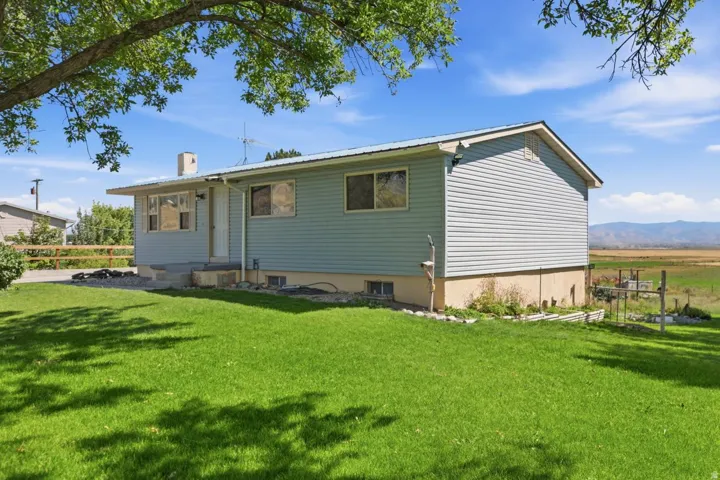Siding exterior with a light blue finish, contrasting white trim, and a metal roof