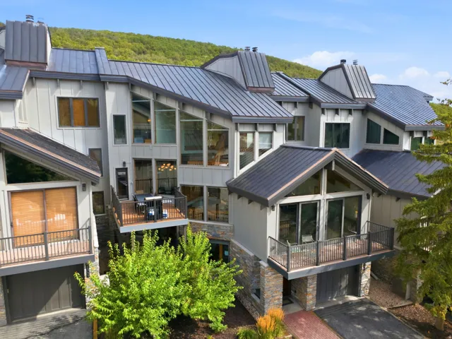 Multi-level exterior with a metal roof and stone accents