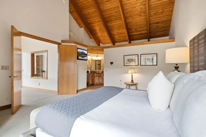 Vaulted wood-paneled ceiling with exposed beams, wood-finish doors, and wood-finish trim throughout