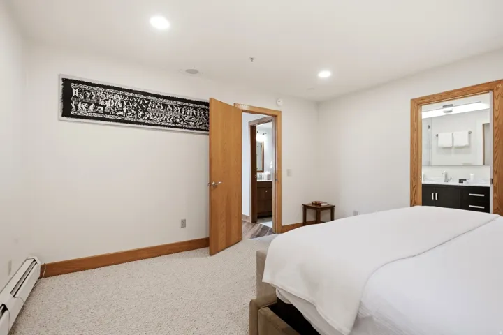 White walls, recessed lighting, and wood-trim doorways