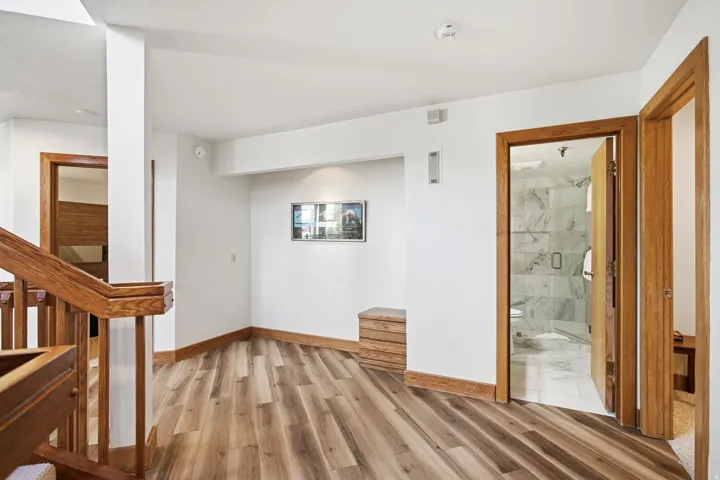 Wood-finish flooring, wood trim, and a wood staircase with balusters