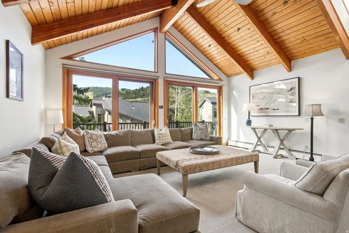 Vaulted wood-paneled ceiling, exposed wood beams, and a ceiling fan