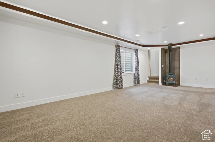 Recessed ceiling lighting, wood-beam ceiling trim, carpeted flooring, and a window with blinds