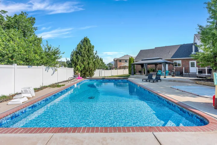 Swimming pool with brick coping and concrete surround